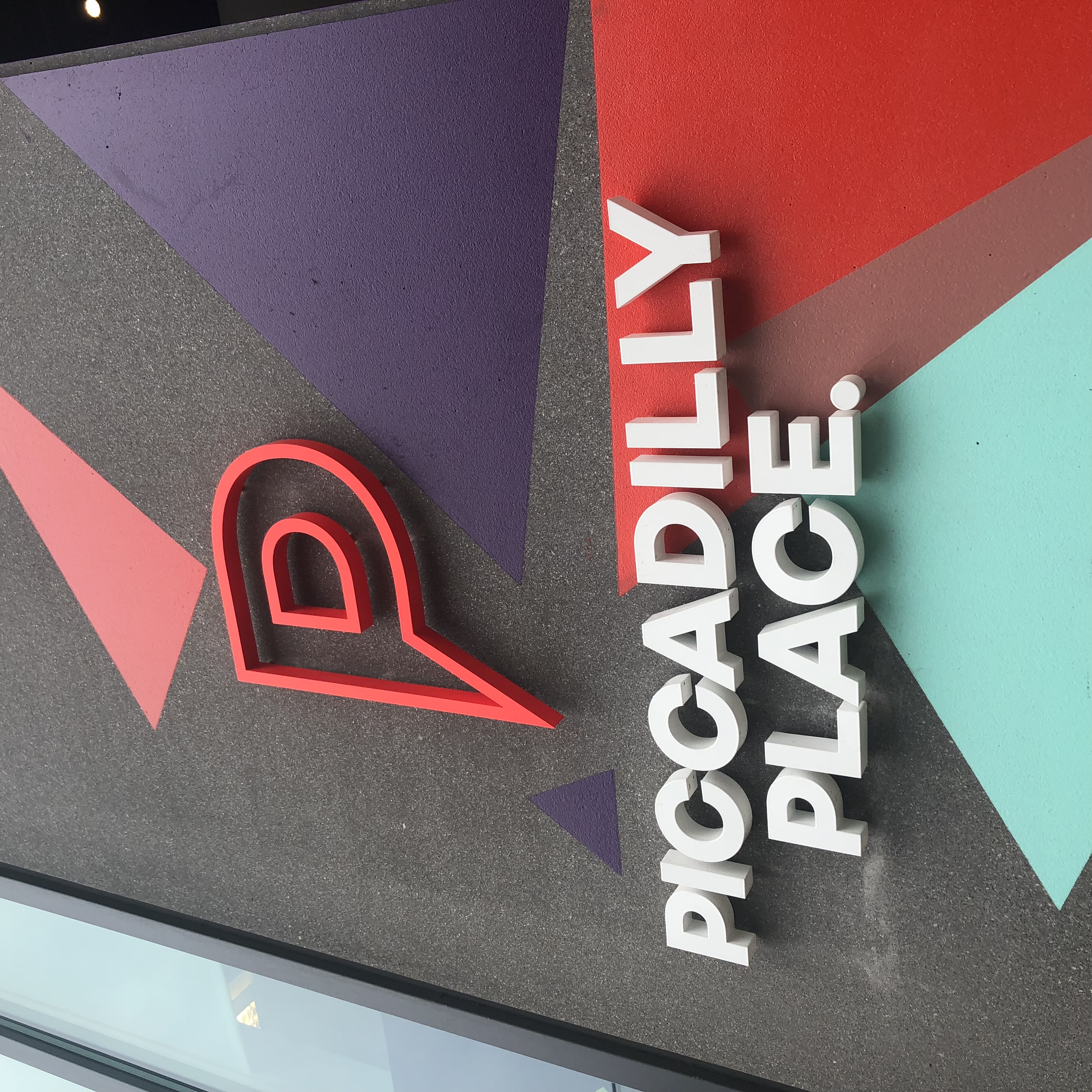 Piccadilly Place built-up dimensional lettering and pin logo on a geometric coloured wall